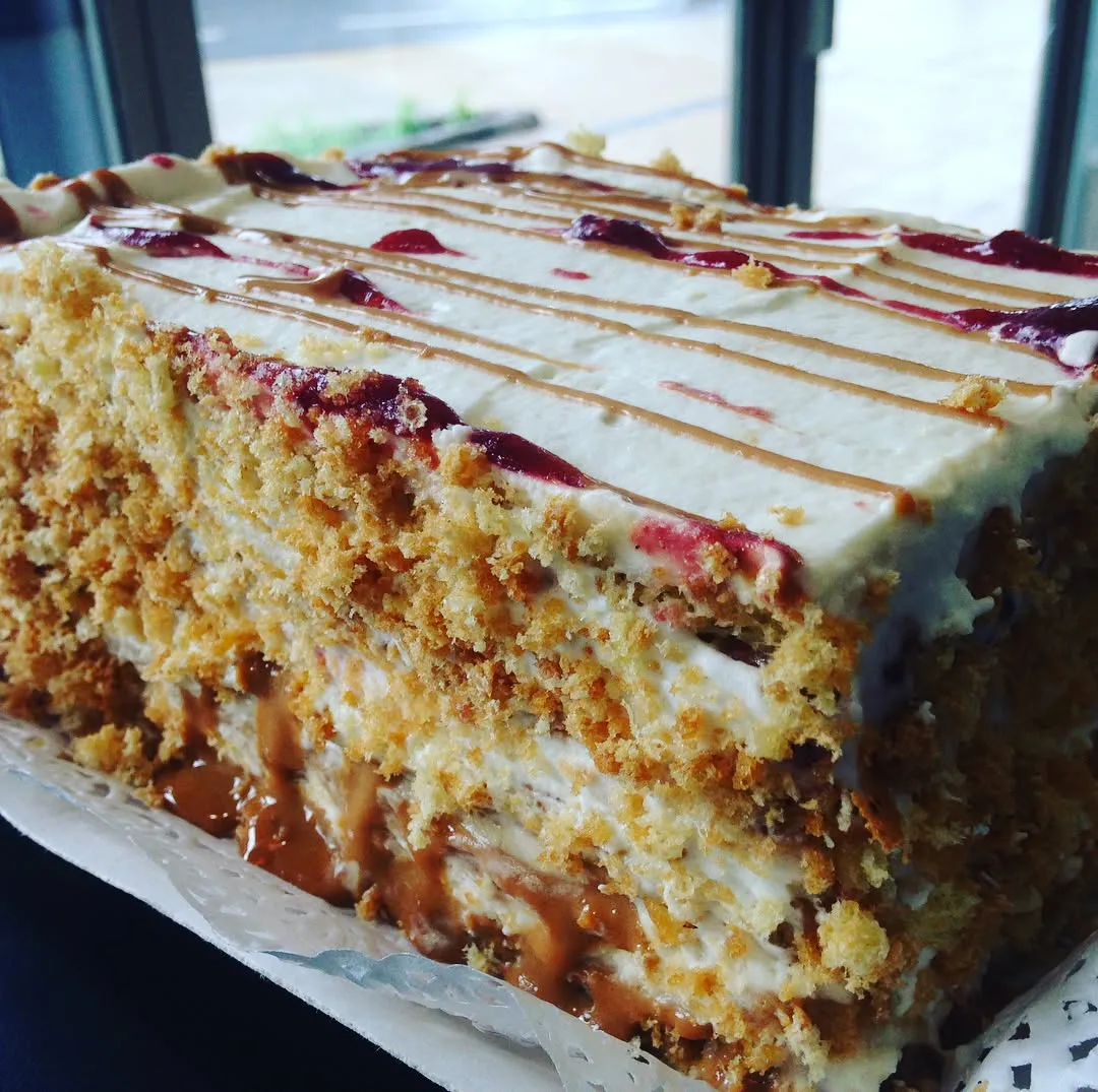 Trozo de torta con manjar y frambuesa de Pastelería Cathy Brown
